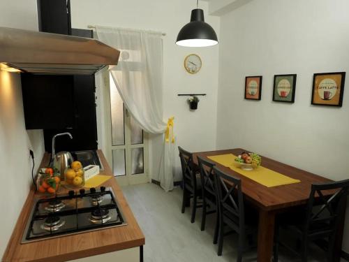 cocina con fogones y mesa con sillas en Regina Margherita Casa Vacanza, en Civitavecchia