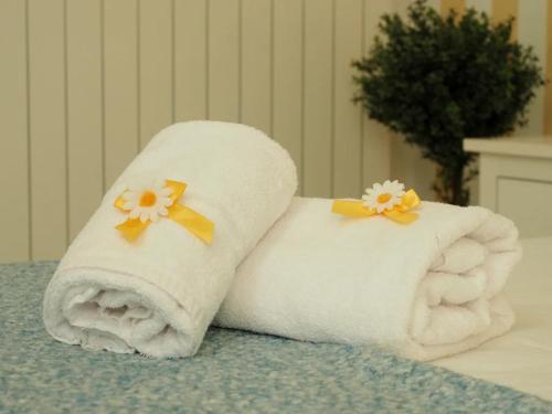 dwa ręczniki z kwiatami na nich siedzące na łóżku w obiekcie Regina Margherita Casa Vacanza w mieście Civitavecchia