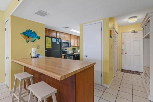 cocina con encimera y 2 taburetes en Driftwood Towers 1G, en Gulf Shores