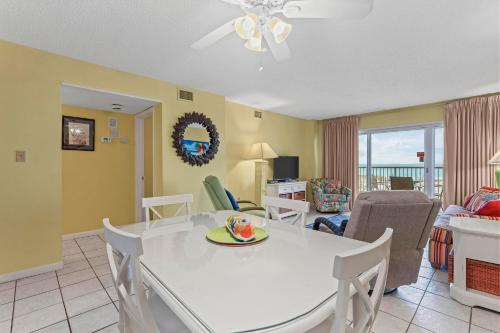 Una sala de estar con una mesa y sillas blancas. en Driftwood Towers 1G, en Gulf Shores