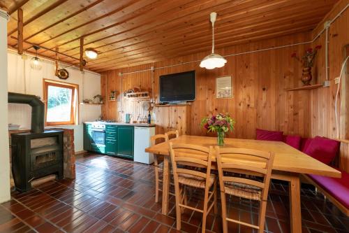 a dining room with a wooden table and a stove at Family Peace Chalet Brinovska & Scenic Mt Views in Ortnek