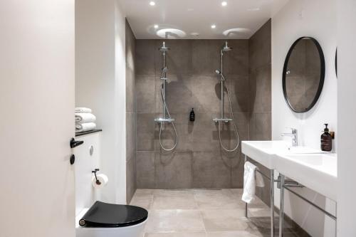 a bathroom with a shower with a toilet and a sink at The Lakes apartments by Daniel&Jacob's in Copenhagen