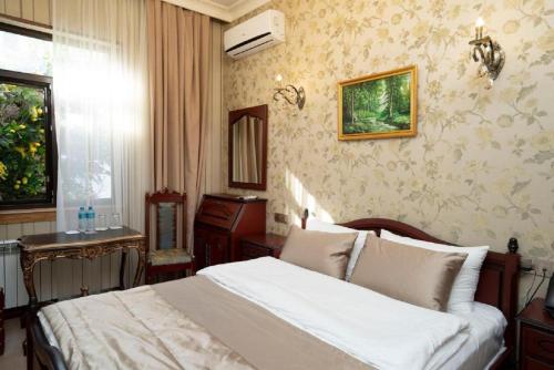 a bedroom with a white bed and a mirror at Royal Historical Boutique Hotel in Baku