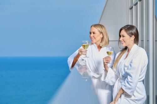 two women holding glasses of white wine at Wyndham Manta Sail Plaza Hotel and Convention Center in Manta