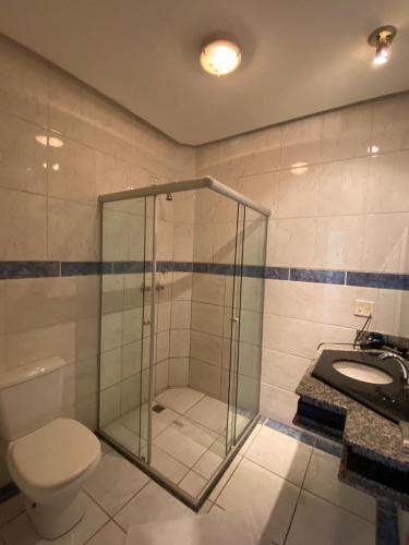 a bathroom with a shower and a toilet and a sink at Villa do Lago in Poços de Caldas