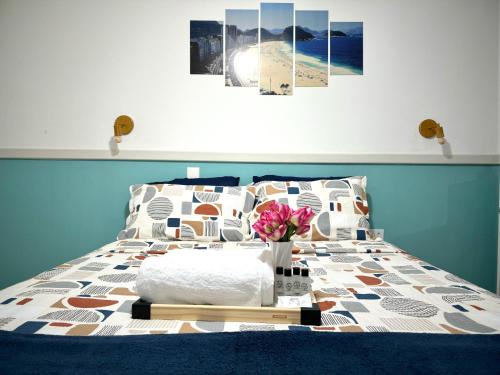 um quarto com uma cama com uma mesa com flores em Apartamento Copa Resort HIR 19 no Rio de Janeiro