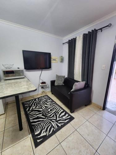 a living room with a couch and a television at Elina Self catering in Ongwediva