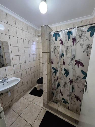 ein Badezimmer mit einem Duschvorhang mit Schmetterlingen darauf in der Unterkunft Elina Self catering in Ongwediva