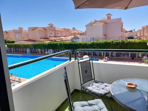 a balcony with a table and a swimming pool at APARTAMENTOS SURYCAN in Maspalomas