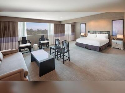 duży pokój hotelowy z łóżkiem i kanapą w obiekcie Luxe Sunset Boulevard Hotel w Los Angeles