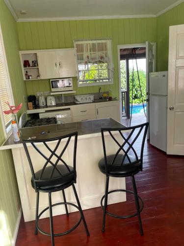 a kitchen with two bar stools and a counter at Montete Cottages in Choiseul