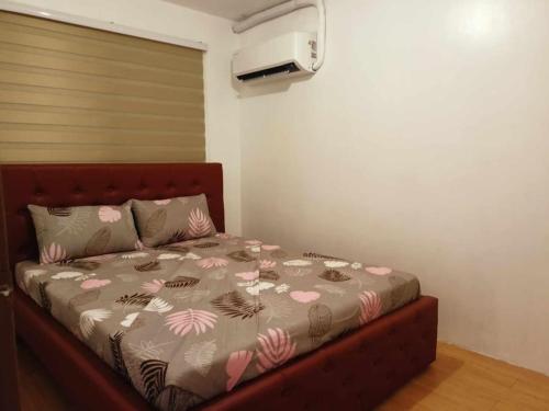 a bedroom with a bed with pink flowers on it at Syv's 2Br & 1T/Bath Condo Oasis Behind SM Mall 411 in Davao City