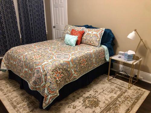 a bedroom with a bed and a table with a lamp at St Louis House near Arch and Ballpark Village in Soulard