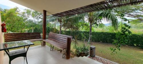 a patio with a wooden bench and a glass table at Chang Noi Hua Hin Pranburi fully accessible barrierefrei resort in Ban Nong Sua