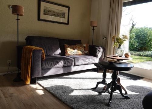 ein Wohnzimmer mit einem Sofa und einem Tisch in der Unterkunft Hof van Benten in Ermelo