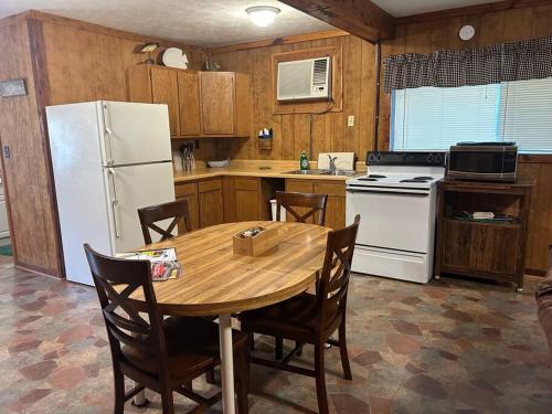 cocina con mesa de madera y nevera blanca en Adjoining Cabin #7A at Patoka 4 Seasons Resort en Scottsburg