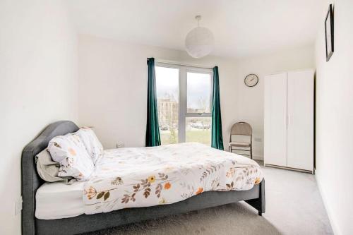 a bedroom with a bed and a window at Beautifully furnished 3-bed apartment near Wembley Stadium in Wealdstone