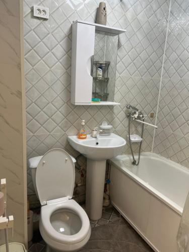 y baño con aseo, lavabo y bañera. en Апартаменты 2-х и 1 комнатные, en Taraz