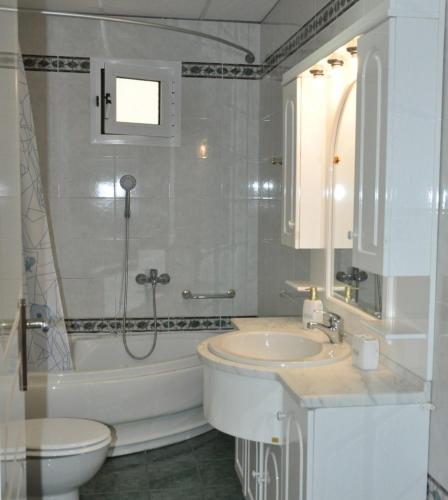 a bathroom with a tub and a sink and a toilet at Diomidi's House in Skala Kallirachis