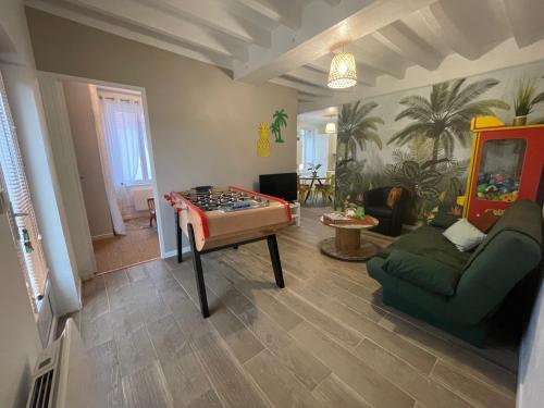 salon ze stołem do gry w piłkarzyki i kanapą w obiekcie la Casa d'Olianna - Jolie Maison / Jeux / Grand jardin w mieście Villeny