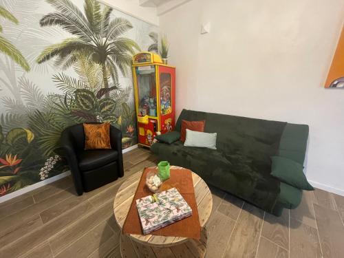 a living room with a black couch and a table at la Casa d'Olianna - Jolie Maison / Jeux / Grand jardin in Villeny