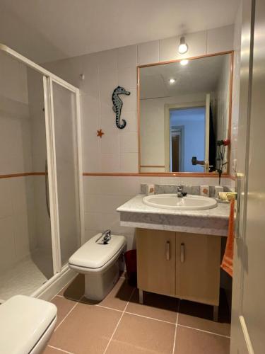 a bathroom with a sink and a toilet and a mirror at Apartamento Guadalquivir - Parking Privado Opt in Seville
