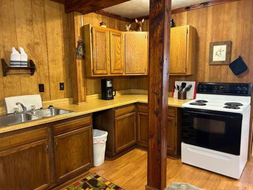 a kitchen with wooden cabinets and a white stove top oven at Adjoining Cabin #7B on Patoka Lake in Southern Indiana in Mitchell