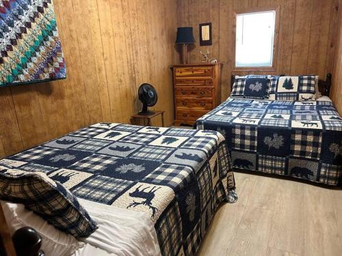 a bedroom with two beds and a dresser at Adjoining Cabin #7B on Patoka Lake in Southern Indiana in Mitchell