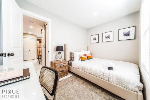 een witte slaapkamer met een bed en een bureau bij Forest Heights Upstairs in Edmonton