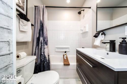 Un baño con lavabo, inodoro y espejo. en Park Life Retreat - King Bed - Pet Friendly - Sleeps 6, en Edmonton