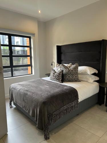 a bedroom with a large bed with a large window at The Fitz Apartment in Johannesburg