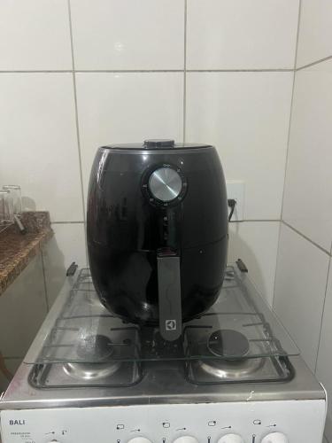 a black appliance sitting on top of a stove at Hotel Ceres - suíte Artista Helo - 25 in Cuiabá