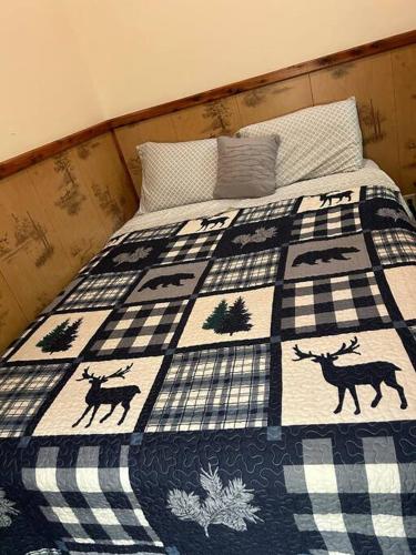 Una cama con un edredón con animales. en Deluxe Cabin #8 w/Jacuzzi at Patoka 4 Seasons Resort, en Mitchell