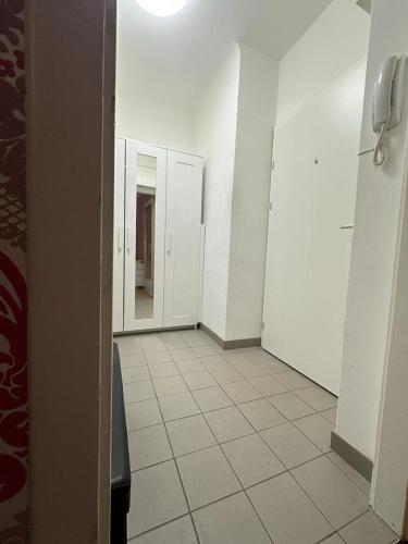 einen Flur mit weißen Wänden und Fliesenboden in der Unterkunft 1Bedroom Apartment in Wien