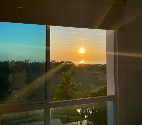 une fenêtre avec vue sur le coucher du soleil dans l'établissement PlayaBlanca Ocean Blue "Vista al Mar", à Playa Blanca