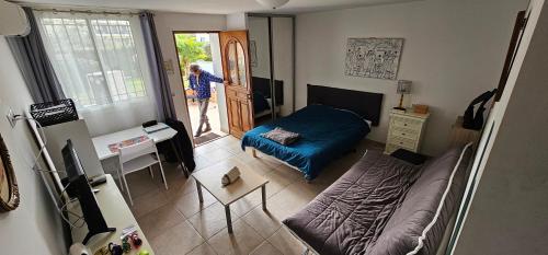 une personne debout dans une chambre avec un lit et une porte dans l'établissement GRAND Studio meublé-Juan Pins-Logt 4, à Antibes