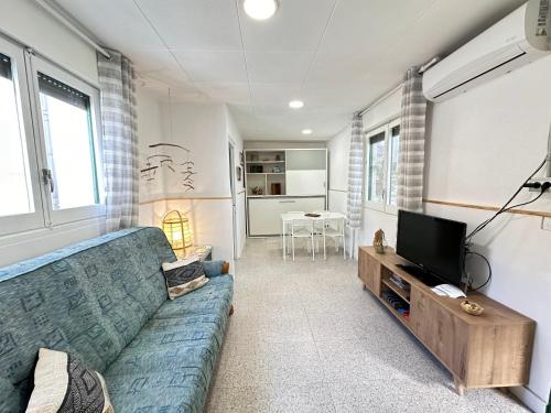 a living room with a blue couch and a television at Apartamento con terraza Delta Slow in Deltebre