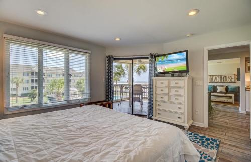 um quarto com uma cama e uma televisão de ecrã plano em 203 Tidewater by AvantStay Beach Condo w Communal Pool em Isle of Palms