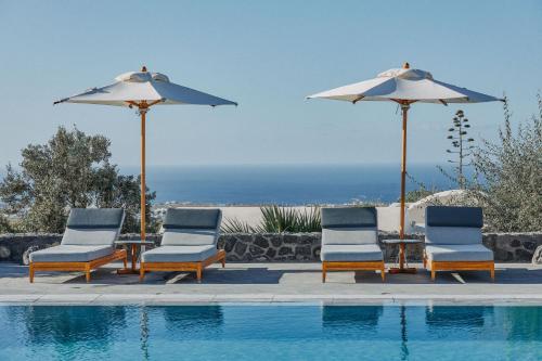 a group of chairs and umbrellas next to a swimming pool at Vedema, a Luxury Collection Resort, Santorini in Megalokhori