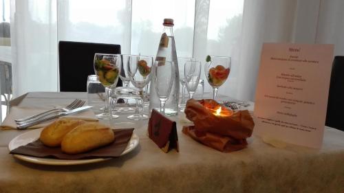 a table with glasses of wine and food on it at Hotel Umberto in Rosolina Mare