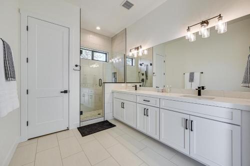 een witte badkamer met 2 wastafels en een douche bij Flagstaff Group Getaway with Game Room and Deck in Flagstaff