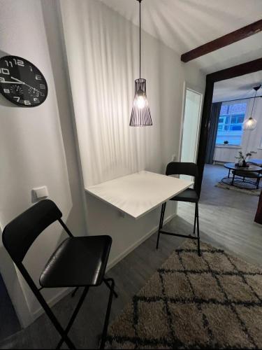 a dining room with a table and chairs and a clock at Gemütliche Ferienwohnung mitten in der historischen Stader Altstadt in Stade