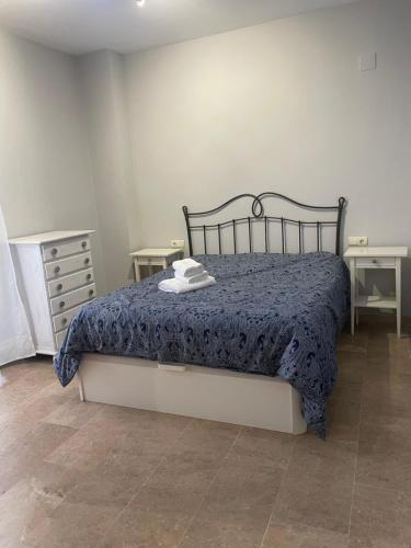 1 dormitorio con 1 cama con edredón azul en PISO EN EL CENTRO DE HUELVA SILENCIOSO Y CON GRAN PATIO, Calle La Paz, en Huelva
