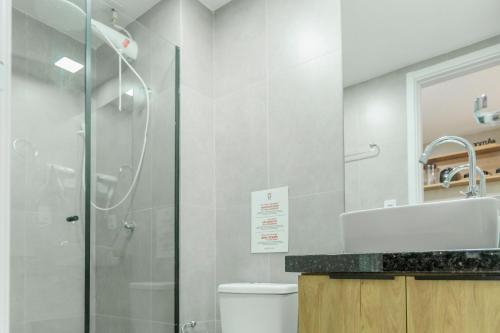 uma casa de banho com um chuveiro, um WC e um lavatório. em Studio perfeito em Poços de Caldas MG PGO310 em Poços de Caldas