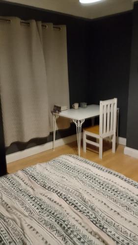 a table and a chair in a room with a rug at Twenty-six in King's Lynn