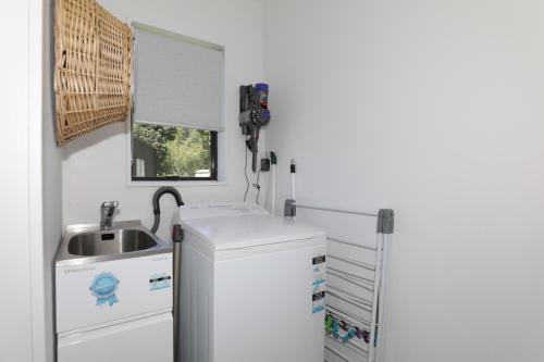 a bathroom with a sink and a washing machine at Rad Little Pad in Rotorua