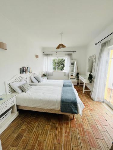 a large white bedroom with a large bed in it at Casa Da Praia in Luz