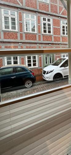 two cars parked in front of a brick building at Gemütliche Ferienwohnung mitten in der historischen Stader Altstadt in Stade