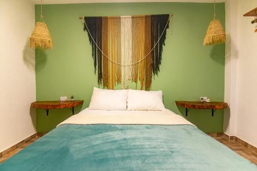uma cama num quarto com paredes verdes em Waikiki Beach em Dibulla