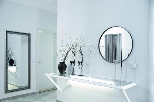 a mirror and vases on a white shelf in a room at Zoe's House in Polykárpion